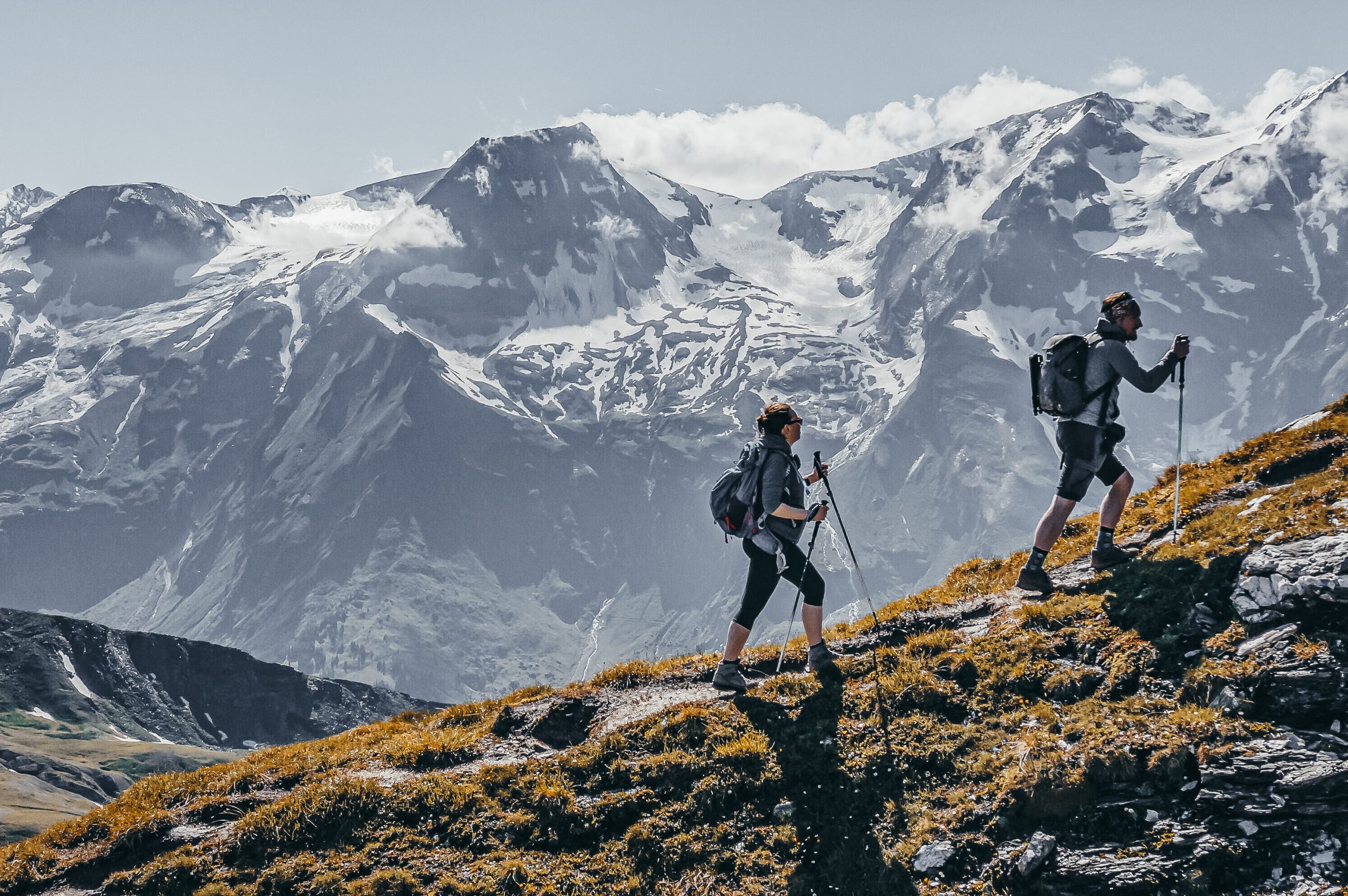 an adventurous couple hiking up a mountain trail